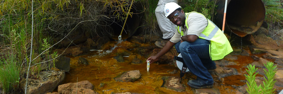 Alan Kumassah conducting water samples on a diversion at the Oak Hill mine in Rusk County, Texas